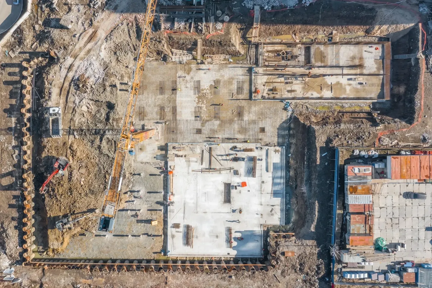 Aerial view of a large construction site with a concrete foundation being laid.